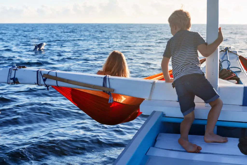 Children on a traditional Bali boat watching dolphins during a Bali family itinerary