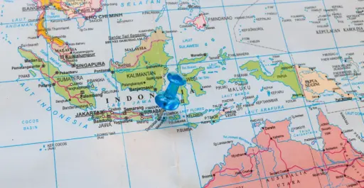 A close-up map of Indonesia and Southeast Asia with a blue pushpin marking the island of Bali, indicating it as a travel destination.